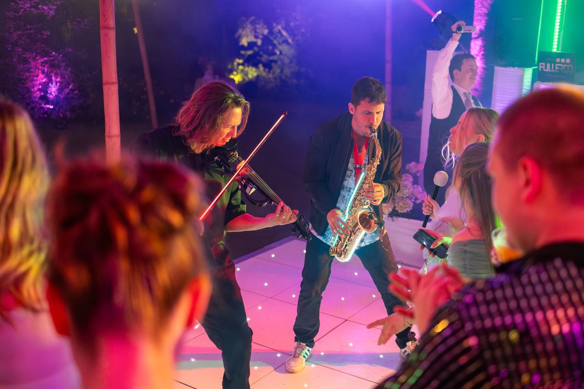 Sax Kid Marbella y un violinista actuando en la pista de baile durante una fiesta